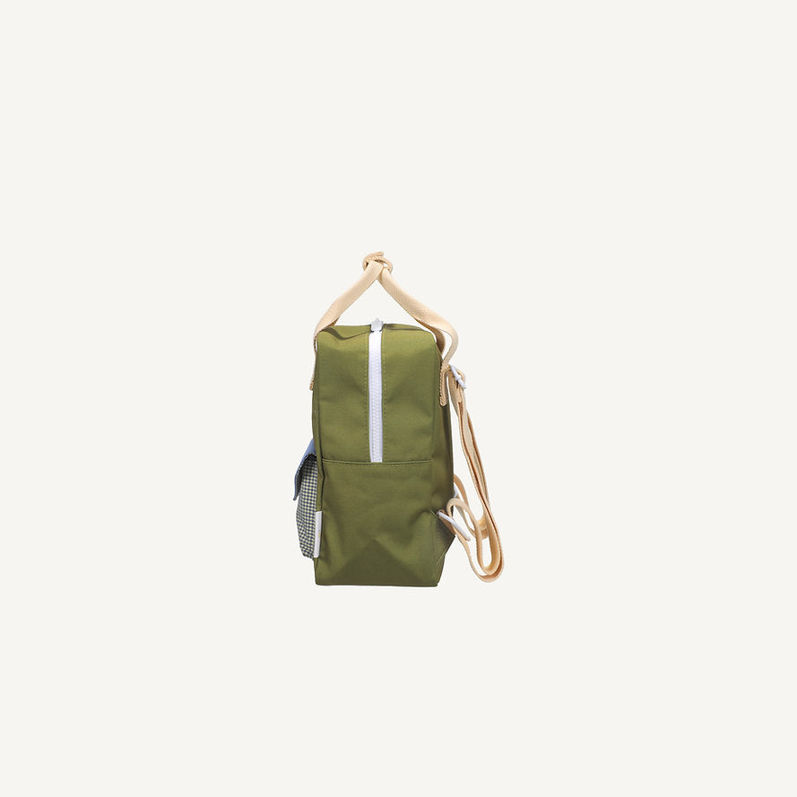 Side view of the Sticky Lemon Backpack Small - Envelope - Tickling Grass: green with tan handles/straps, front zipper, small checkered side pocket, made from recycled PET bottles, shown on a plain white background.