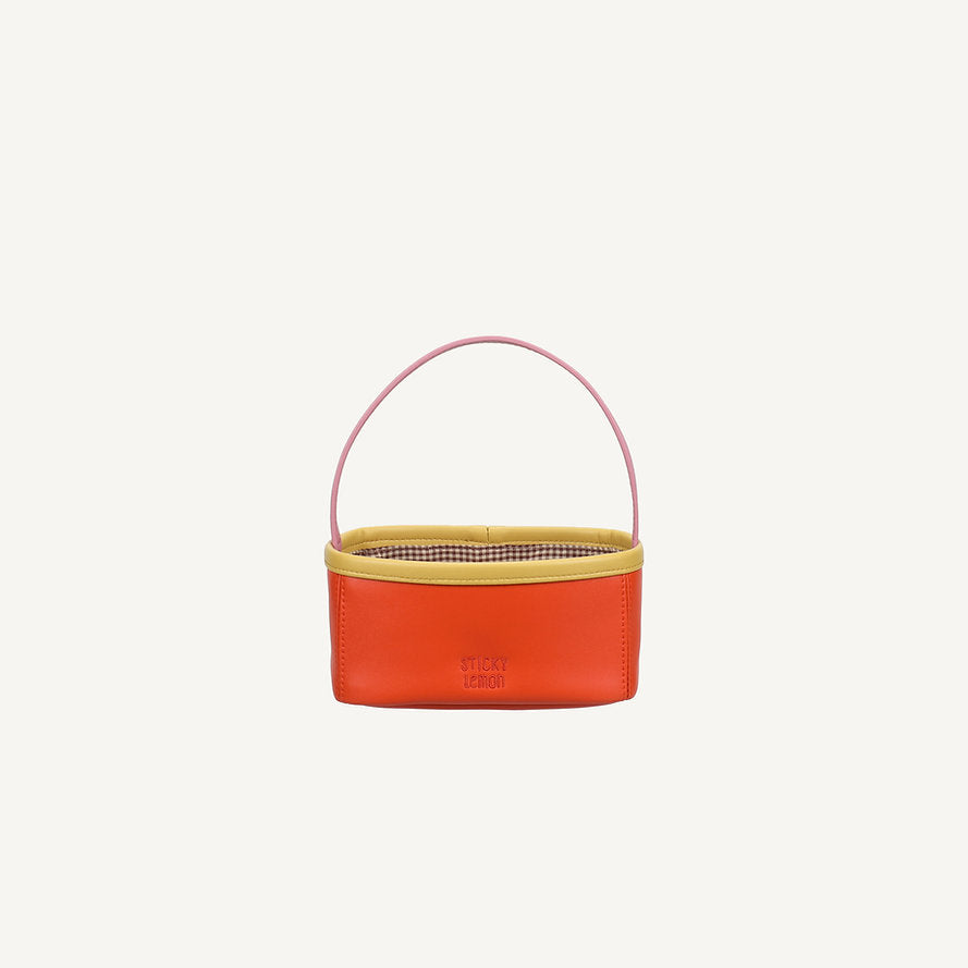 The Sticky Lemon Treasure Bag - Campfire Orange is a small rectangular PU leather bag featuring an orange body, yellow trim, pink handle, and checkered interior, shown against a plain white background.