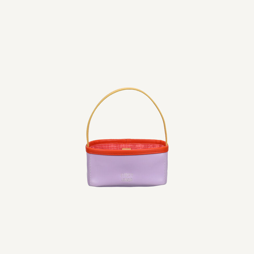The Sticky Lemon Treasure Bag - Dewy Lilac is a small rectangular PU leather bag with a pale purple body, red top edge, yellow handle, and textured red interior, shown on a plain white background.