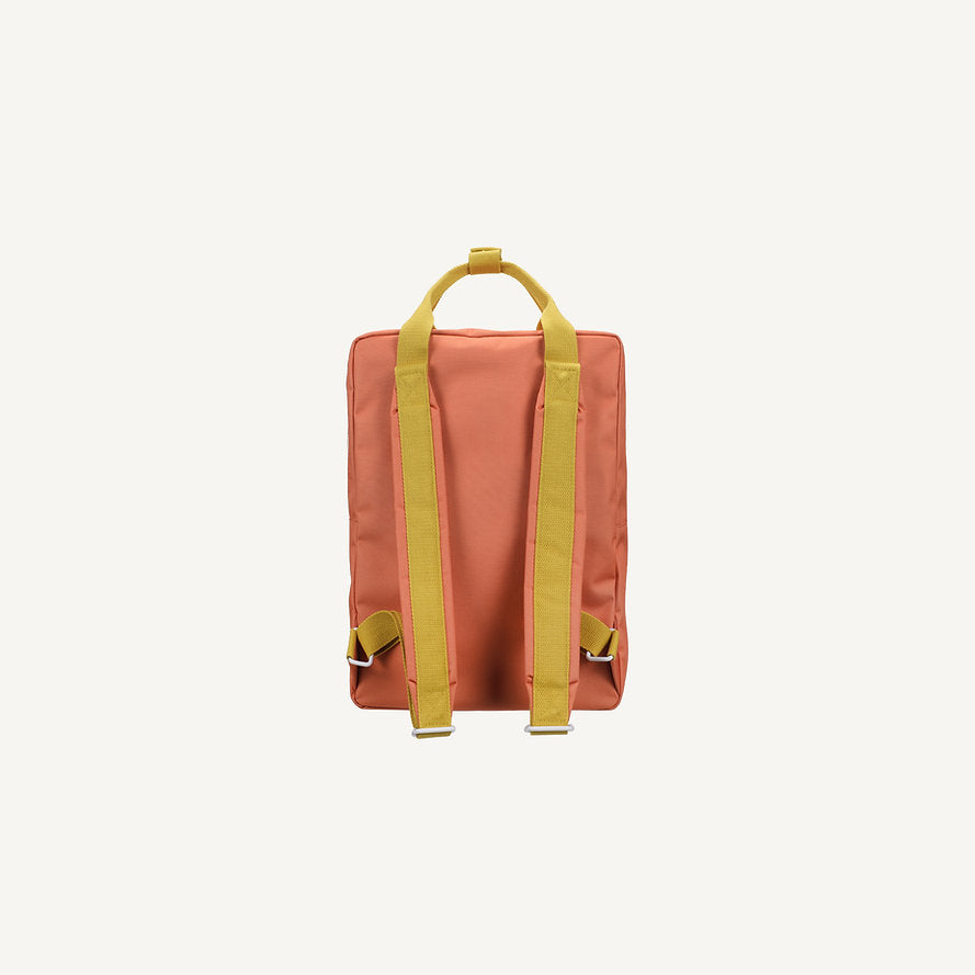 The Sticky Lemon Backpack Large - Envelope - Maple Whirl is a rectangular orange kids backpack made from recycled PET bottles, with yellow adjustable shoulder straps and a matching top handle, shown against a plain white background.