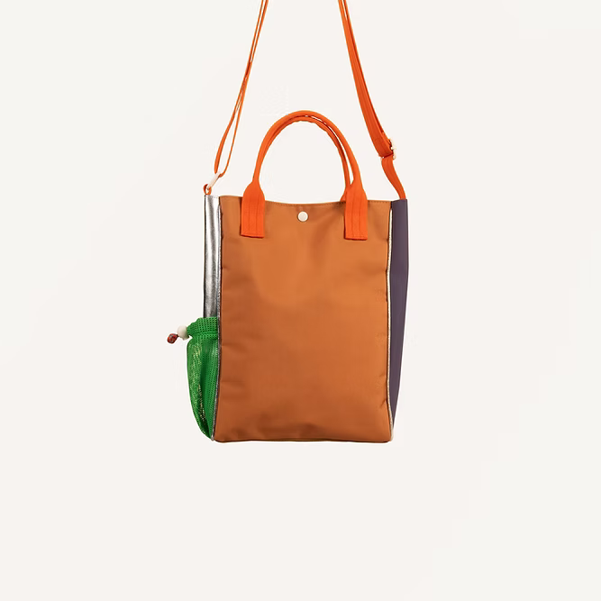 The Sticky Lemon Shoulder Bag | Leather Ball + Golden Cup features color-blocked panels in brown, silver, purple, and green mesh with orange handles and strap, crafted from recycled PET bags and shown against a plain white background.