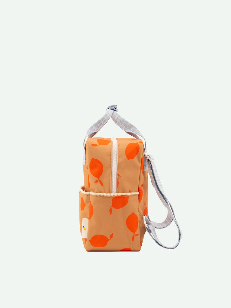 Sticky Lemon Backpack Small | Farmhouse | Special Edition with white and yellow floral pattern, featuring a front pocket with a YKK zipper and gray straps, isolated on a white background.