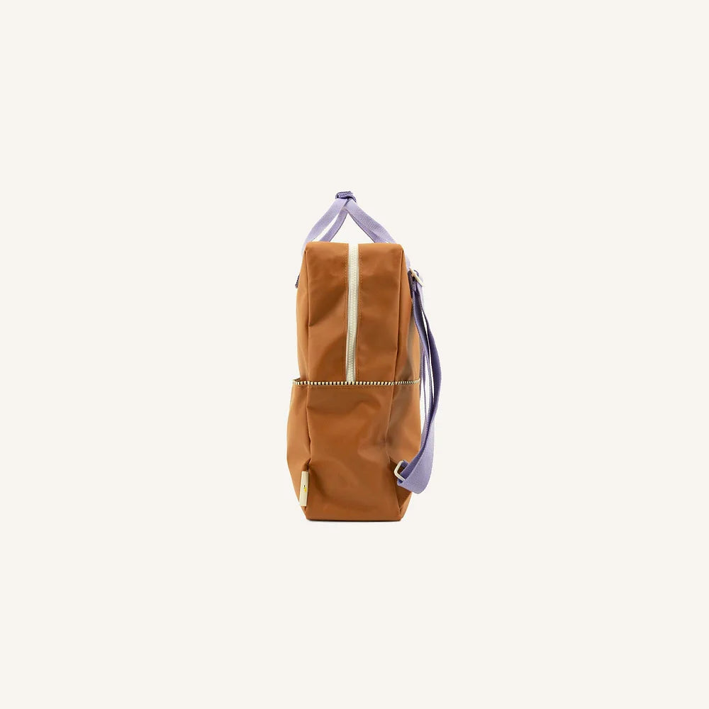 A Sticky Lemon Backpack | Uni | Buddy Brown with purple straps and YKK zippers, displayed upright against a white background.