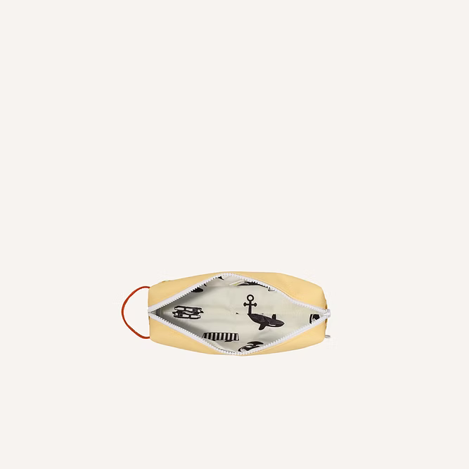 A light yellow face mask with white trim and a red ear loop, shown open to display a whimsical black-and-white animal print lining—similar to the playful designs on the Sticky Lemon Pencil Case | Color Blocking | Sandy Yellow + Radar Blue.