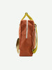 A Sticky Lemon Backpack Large from the Envelope Collection in Lighthouse Red, made from waterproof nylon with neon yellow straps, displayed on a white background. It features a vertical front zipper and a visible side pocket.