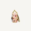 Side view of the Sticky Lemon Backpack Small - Special Edition - Snail Mail in beige with red, purple, and pink geometric patterns. Made from recycled PET bottles with a yellow handle, waterproof lining, and small front pocket. Off-white background.