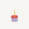 The Sticky Lemon Treasure Bag - Dewy Lilac features a small square shape with a purple body, red rim, yellow handle, and a red grid-patterned interior, displayed against a plain white background.