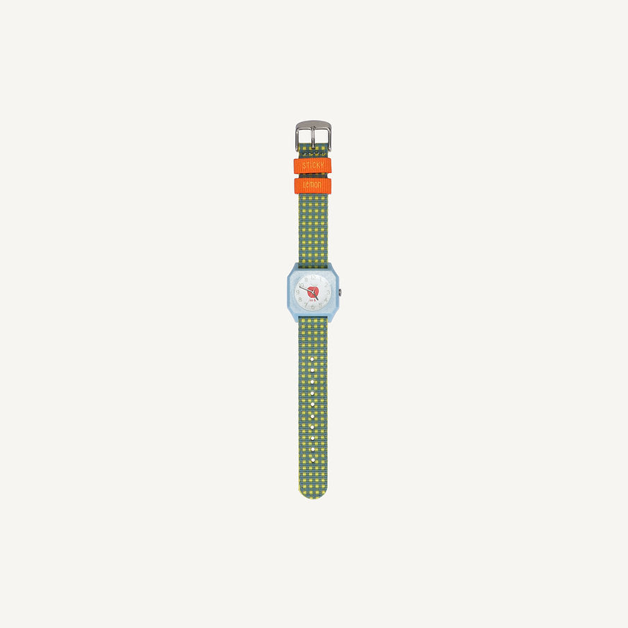 The Sticky Lemon x Mini Kyomo Watch - Apple is a kids' watch with a green patterned strap, two orange bands labeled "ENERGY" and "LEGEND," and a silver rectangular face, shown against a plain white background.