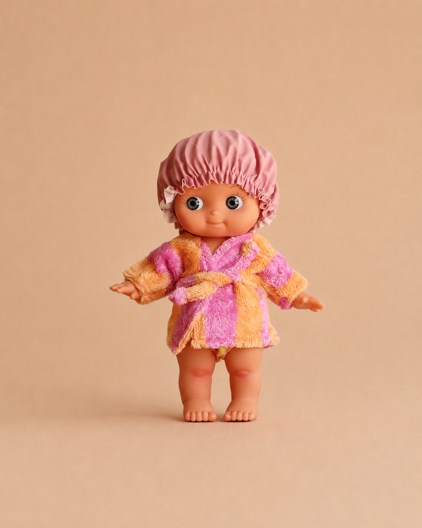 The Mini Pancha Doll - Alice with Pink Striped Bath Set is a high-quality vinyl figure with wide eyes, wearing a pink-striped shower cap and a matching pink and yellow robe, standing barefoot against a plain beige background—perfect for inspiring imaginative play.