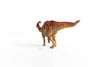 The Schleich Parasaurolophus Large Dinosaur Toy—a plastic figurine with a brown body, red back, and green crest—stands on a white surface against a plain white background, facing away from the camera. It makes an ideal dinosaur gift for young enthusiasts or collectors of Schleich Dinosaurs.