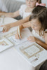 A child uses a water pen to color in a Winnie-the-Pooh: Pooh’s Birthday Surprise (Water Reveal) book.
