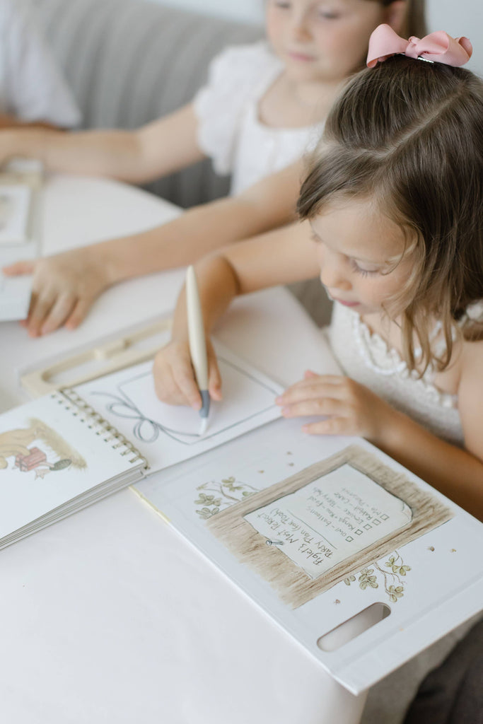 A child uses a water pen to color in a Winnie-the-Pooh: Pooh’s Birthday Surprise (Water Reveal) book.