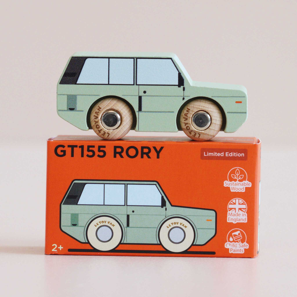 A mint green wooden 4x4 toy car, No. 28 GT155 Rory | Made in England, sits atop an orange box featuring classic British design and icons for sustainable wood, child-safe paints, and UK manufacturing. Suitable for ages 2 and up, this adventure toy is both stylish and safe.