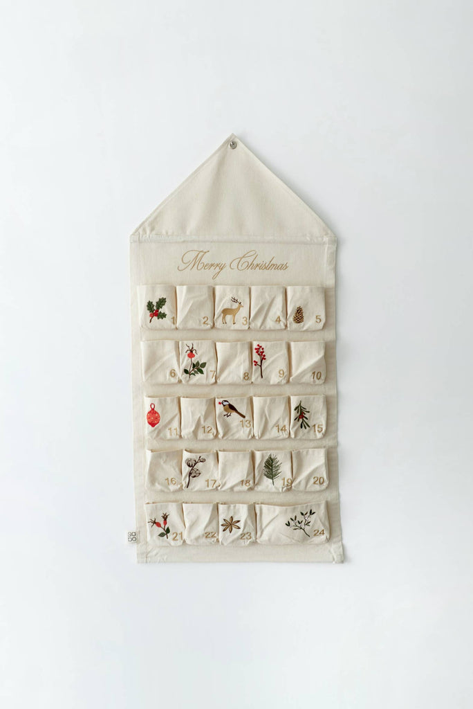The Sabo Concept Christmas Cotton Advent Calendar is a cream-colored calendar with 24 numbered pockets, each featuring festive embroidery such as holly, birds, and pine branches. "Merry Christmas" is written in gold script at the top.