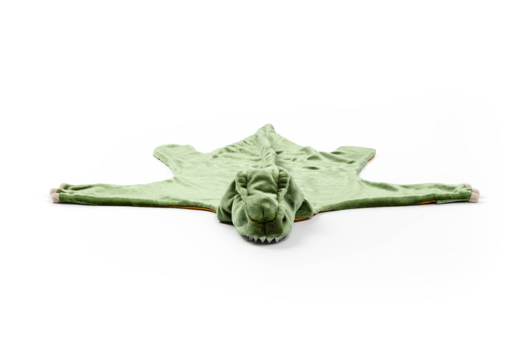 The Costume - T-Rex Dino is a green, plush blanket shaped like a dinosaur with a head, soft teeth, four legs, and cozy faux fur, shown on a white background.