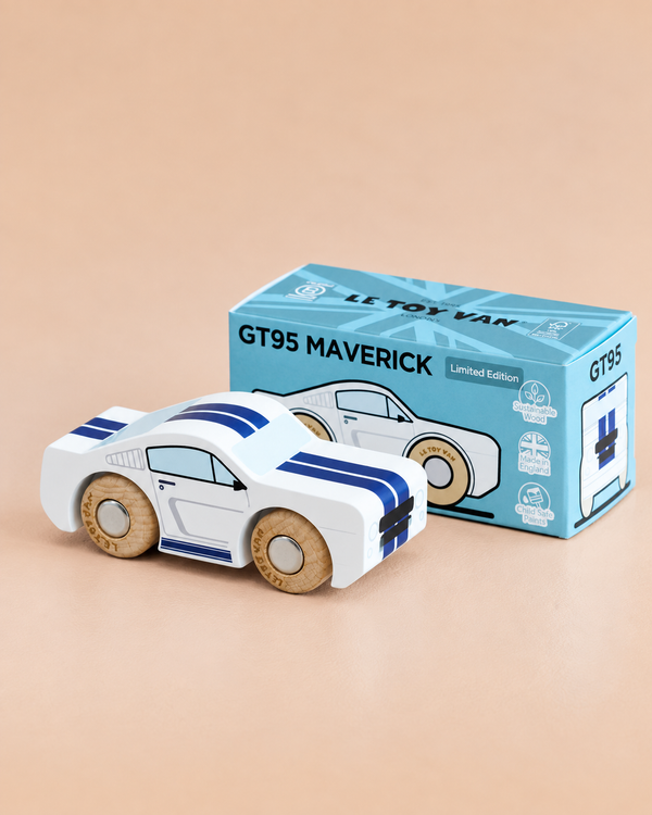 A white wooden toy car with blue stripes, inspired by iconic muscle car designs, is displayed next to its blue packaging box labeled “No. 17 GT95 Maverick | Made in England” on a beige surface.