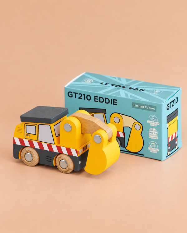 A yellow wooden No. 37 GT210 Eddie construction excavator toy is positioned in front of its blue “Made in England” box, featuring orange and white stripes and gray wheels, set against a beige background—perfect for sparking imaginative building site adventures.