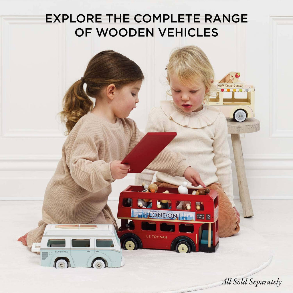 Two young children enjoy imaginative play with colorful wooden vehicles, such as the Mobile Café Van, a red London bus, and an ice cream truck. Text above reads: "Explore the complete range of wooden vehicles.