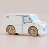 The No. 32 GT175 Frank | Made in England is a minimalist classic wooden toy van, finished in white with simple black outlines and natural wood wheels, set against a pale pink background—perfect for inspiring imaginative play.
