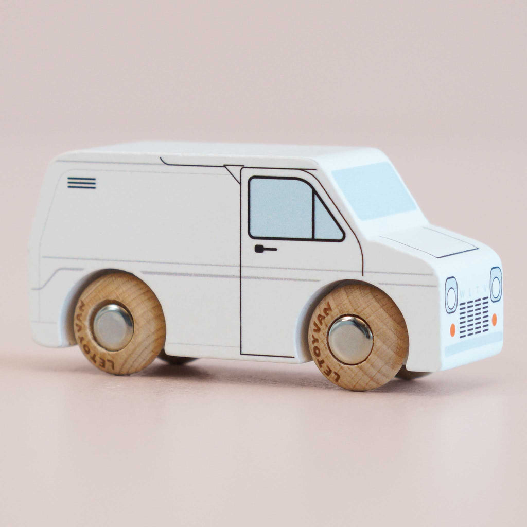 The No. 32 GT175 Frank | Made in England is a minimalist classic wooden toy van, finished in white with simple black outlines and natural wood wheels, set against a pale pink background—perfect for inspiring imaginative play.