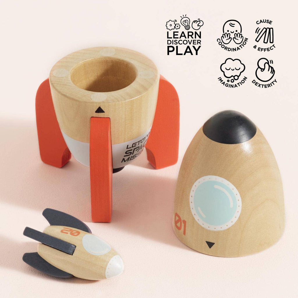 The Magnetic Space Rocket Duo disassembles into three parts: a base with red legs, a middle section, and a nose cone. A small spaceship is included for creative play. Educational icons and text are shown in the upper right corner.
