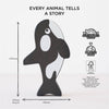 The Ocean Life Stacking Animals & Bag features a wooden orca figure standing upright on a white background. Text above says "Every animal tells a story." Crafted from sustainable wood, it’s plastic-free and labeled with measurements for sensory play.