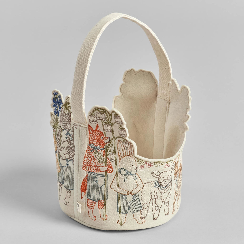 The Coral & Tusk Easter Parade Basket features charming animals like a fox, rabbit, and lamb in clothing with floral elements stitched in earthy tones on a cream background, adding a delightful touch to your festive décor.