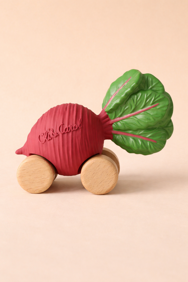 Betty The Beetroot Baby Car features a red wooden and plastic body with a green leafy top, four wooden wheels, and "Oli & Carol" embossed on the side—an eco-friendly, charming toy for little ones.