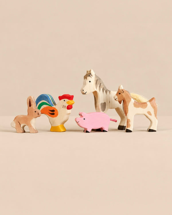 A set of Holztiger Handmade Wooden Farm Animals including a rabbit, a rooster, a pig, a horse, and a goat.