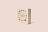 A board book box set titled "Our Little Library Book Box Set" with an illustrated cover design featuring botanical and insect motifs, shown standing upright against a soft pink background.