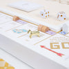 The Monopoly Bianco Edition board game featuring gold metal tokens, wooden houses, and white dice.
