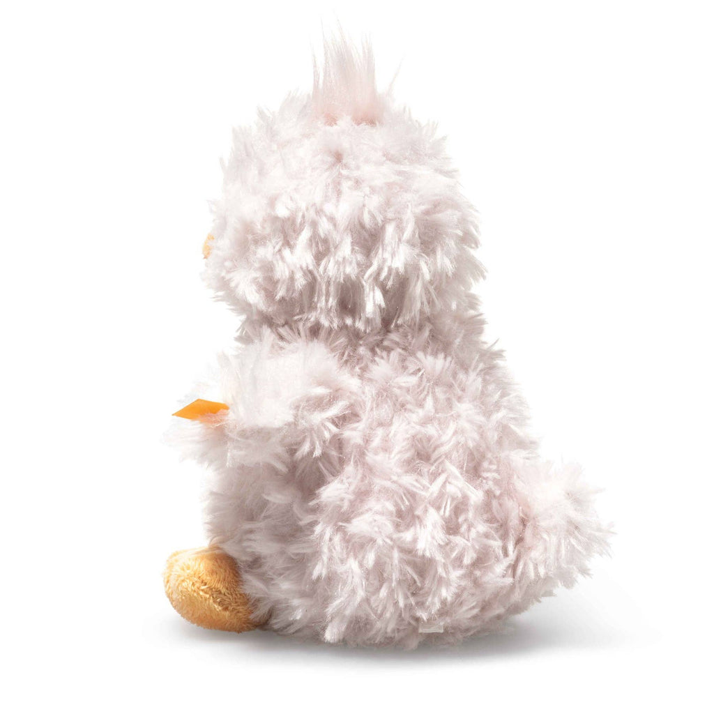The Steiff Pipsy Pink Chick is a fluffy, light pink plush resembling a chick with a soft, fuzzy texture, small beak, and tan feet. Sitting upright in profile against a white background, this adorable stuffed animal is irresistibly cuddly.