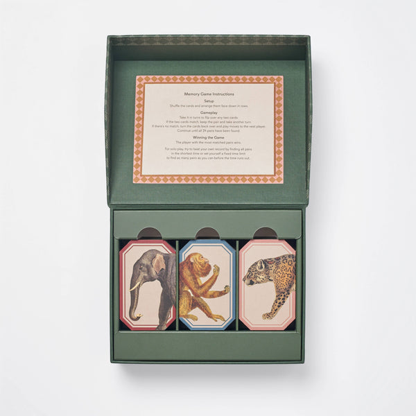 An open green box contains the Memory Game - Animal Kingdom with vintage animal illustrations (elephant, lion, leopard) on top. A card with game instructions is printed inside the lid.