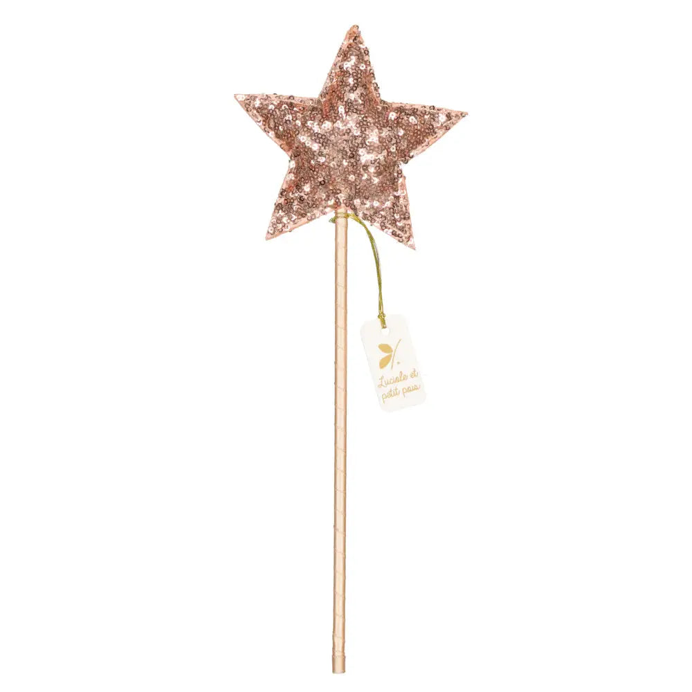 The Magic Wand - Pink Sequin Star by Luciole et Petit Pois features a shimmering star-shaped top adorned with pink sequins, mounted on a sleek wooden stick. A small tag tied with a green string dangles from the stick, adding a whimsical touch to its enchanting design.