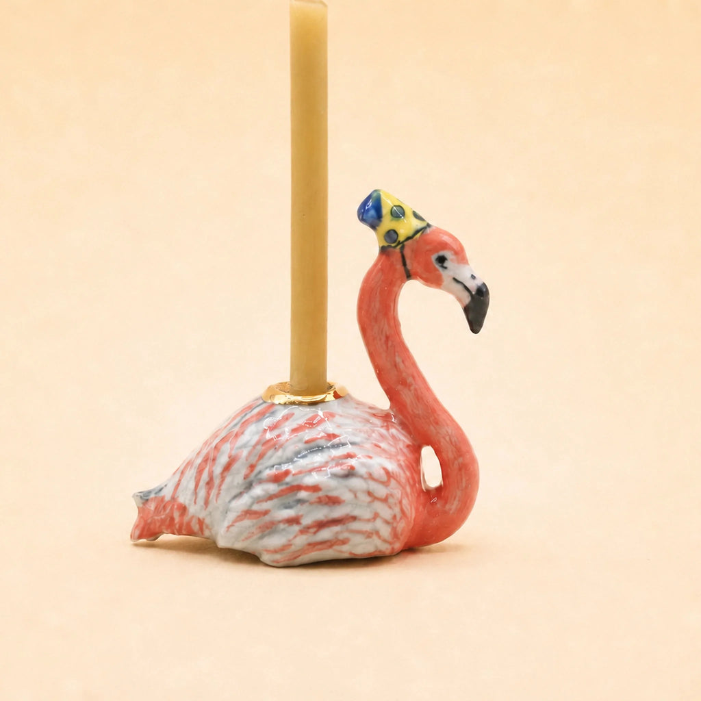The Flamingo Cake Topper - Final Sale (ships in one week) is a charming ceramic flamingo figurine with a crown, perfect as a collectible birthday keepsake or decorative accent.