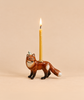 A handcrafted collectible ceramic fox figurine, designed as a “Fox Cake Topper - Final Sale,” features a small burning candle on its back and is set against a plain beige background.