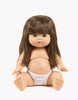 The Minikane Baby Doll (13") - Cherry is an anatomically correct doll made in Spain, featuring long brown hair with bangs, blue eyes, and a neutral expression. Clothing sold separately. Shown seated in white underwear on a plain white background.