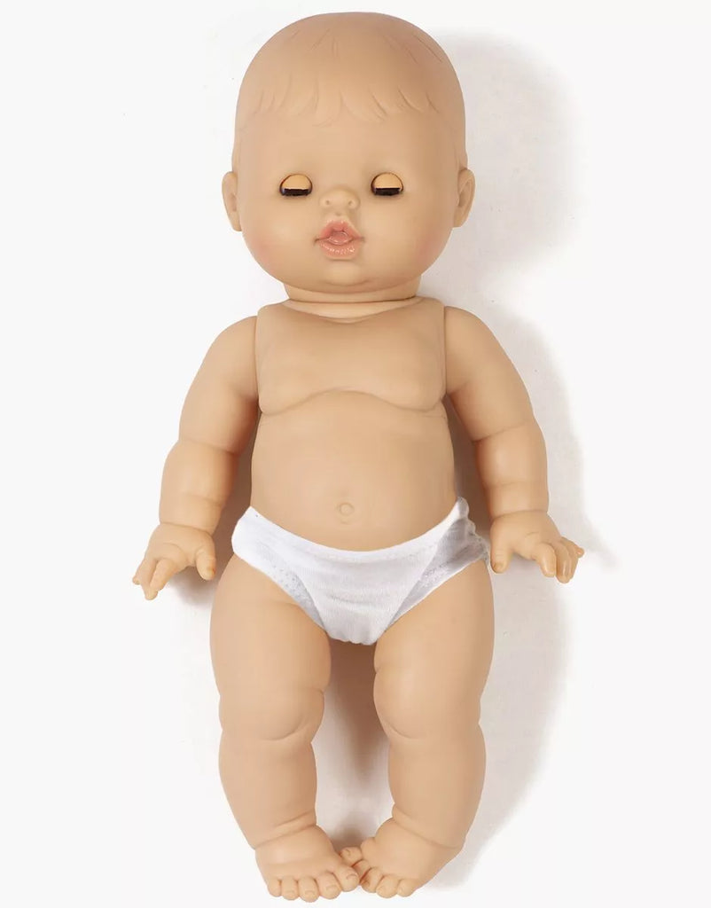 The Minikane Doll with Sleeping Eyes (13") - Lily With Clothing, an anatomically correct doll made in Spain, lies on a plain white background. She has molded hair and closed eyes.