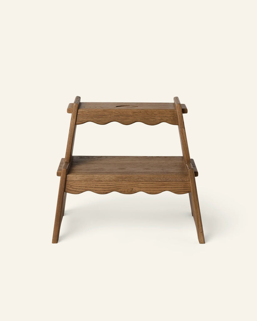 The Häti at Home - Margot Step Stool is a small, two-step kids’ wooden step stool featuring scalloped edge designs on both steps, displayed against a plain light background.