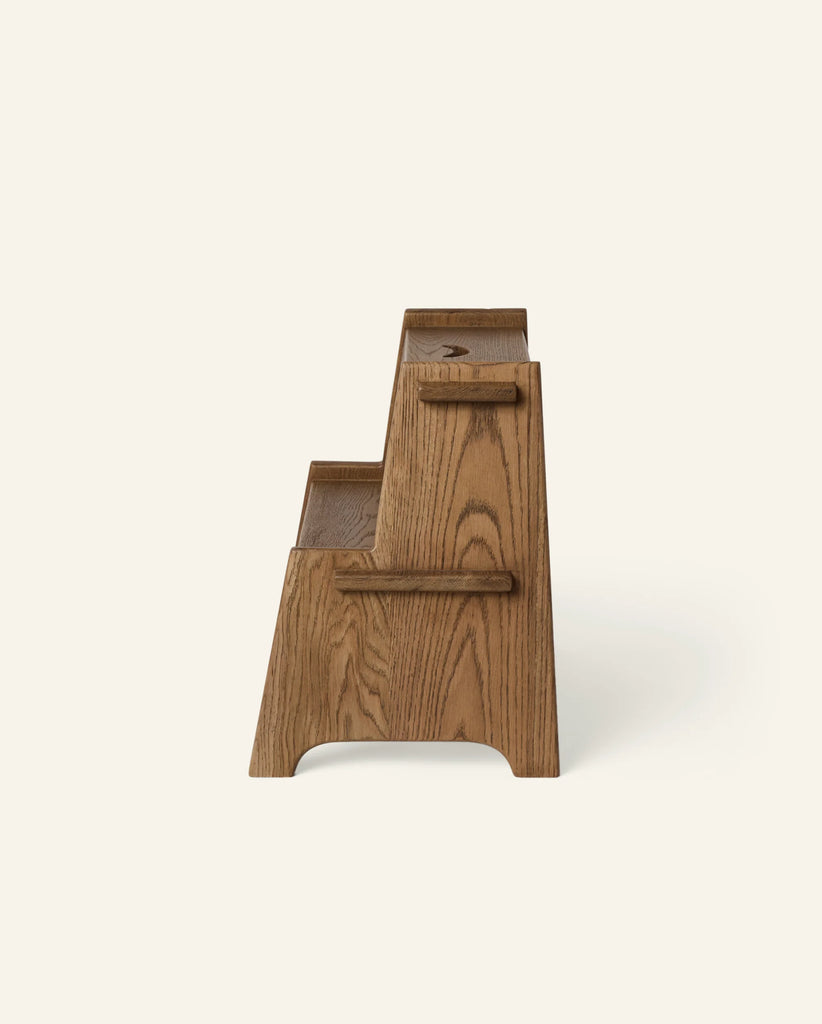Side view of the Häti at Home - Margot Step Stool for kids, featuring two wooden steps with a natural finish and visible wood grain, set against a plain off-white background.