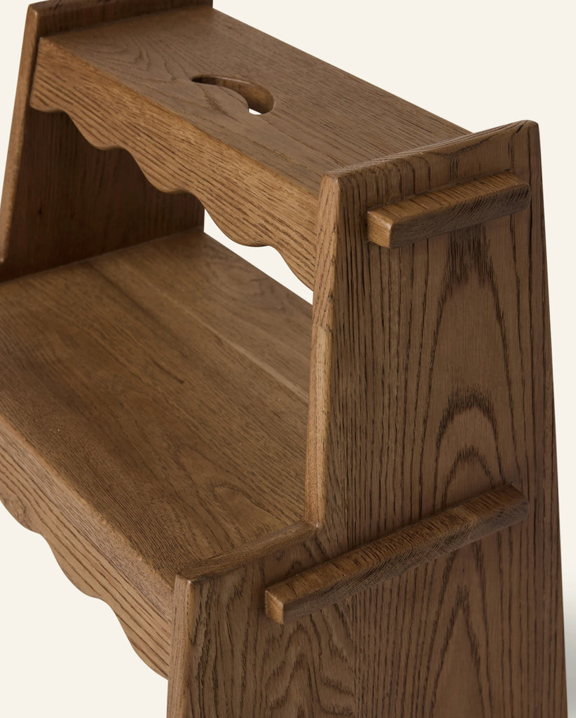 A close-up of the Häti at Home - Margot Step Stool shows two wooden steps, curved edges, visible wood grain, and a rounded notch on the top step for easy carrying.