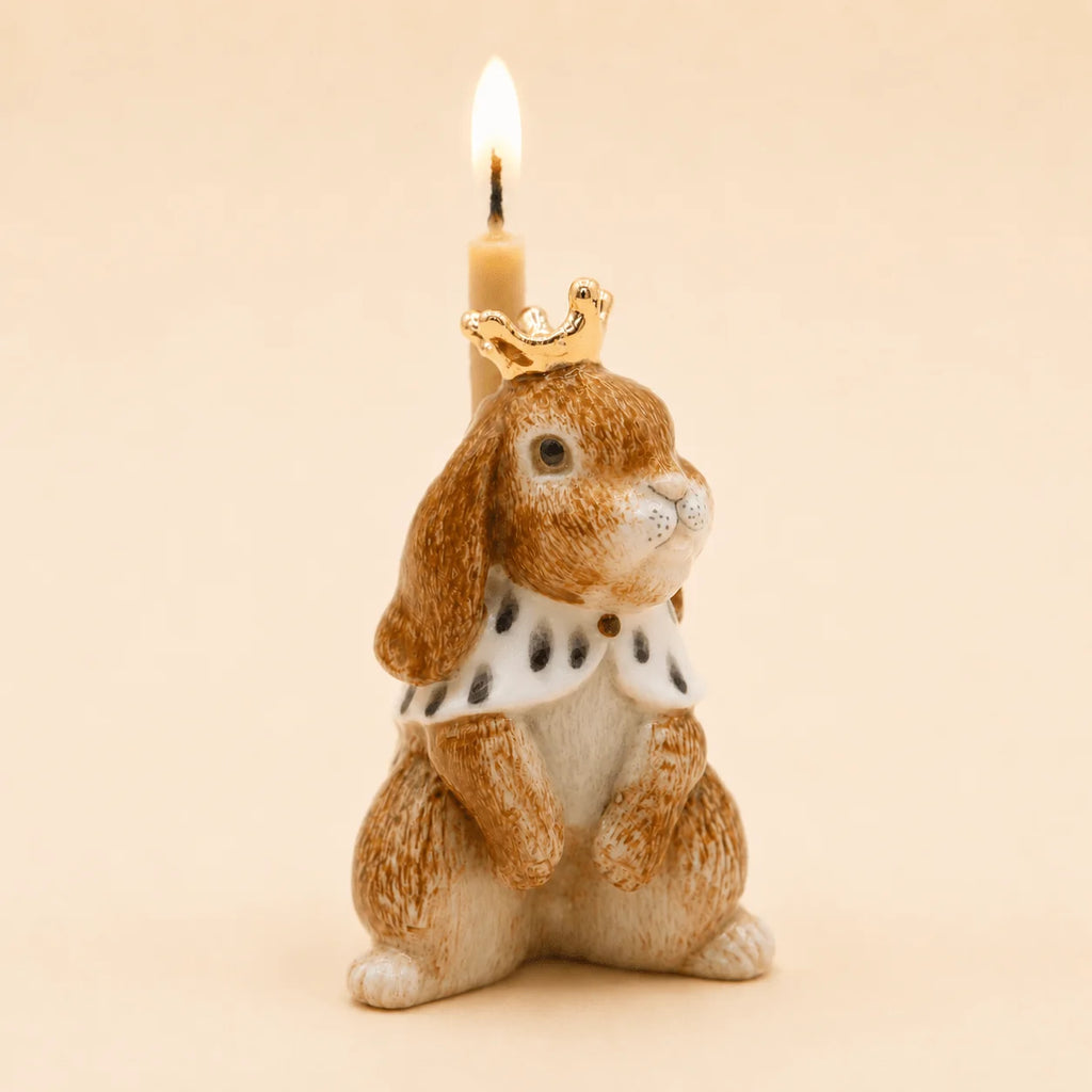 The Highness Hare Cake Topper - Final Sale (ships in one week) features a bunny with a gold crown, royal cape, and candle on its back—a charming collectible against a beige background.