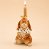The Highness Hare Cake Topper - Final Sale (ships in one week) features a ceramic bunny with a gold crown, royal cape, and a lit beige candle atop its head—perfect as a collectible keepsake.