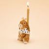 The Highness Hare Cake Topper - Final Sale (ships in one week) is a porcelain bunny figurine with a crown, cape, and lit candle on its back, shown against a solid light beige background.