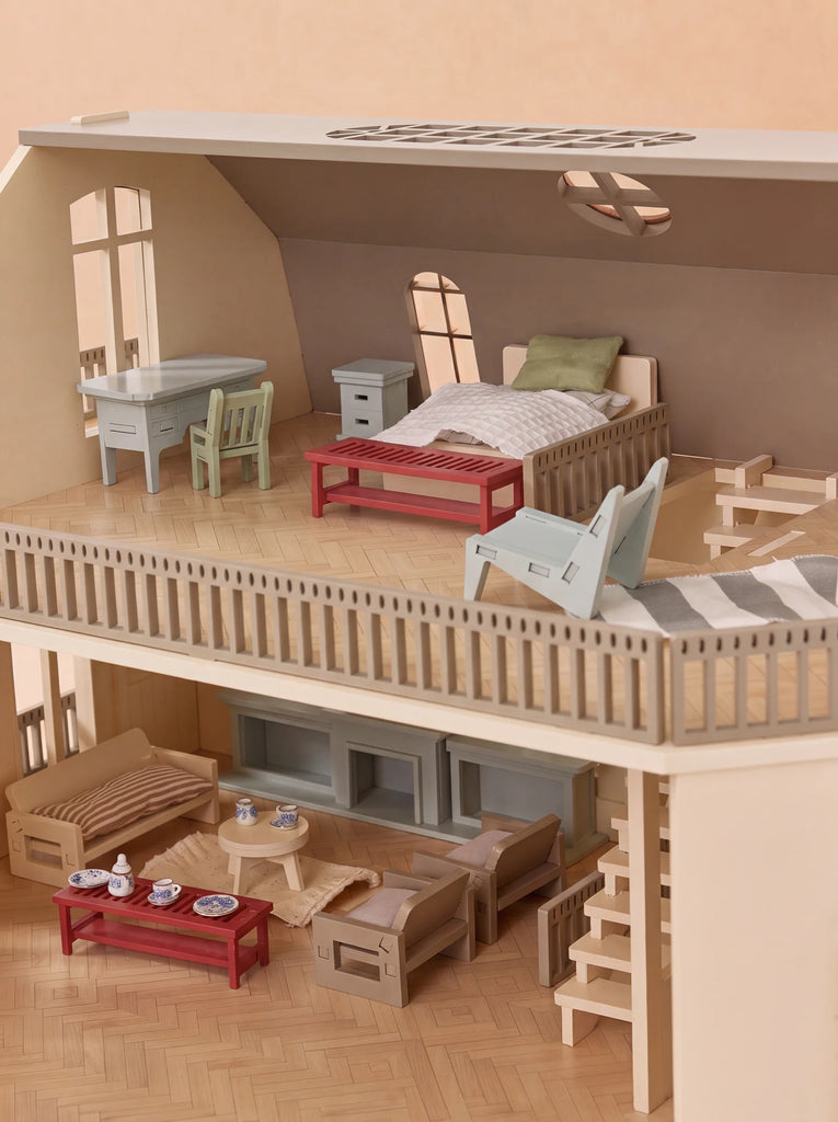 Introducing the House of Paris Luxury Dollhouse – A Tale of Parisian Magic: a two-story luxury dollhouse complete with exquisite miniature furniture, including a bed, tables, chairs, and sofas. The upper floor is designed as an elegant bedroom, while the lower level boasts a stylish living area and an intricate staircase.
