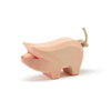 A simple Ostheimer Piglet handcrafted from sustainably sourced materials, painted pink with visible wood grain, featuring a small tail made from twine and red details on the ears and snout, isolated
