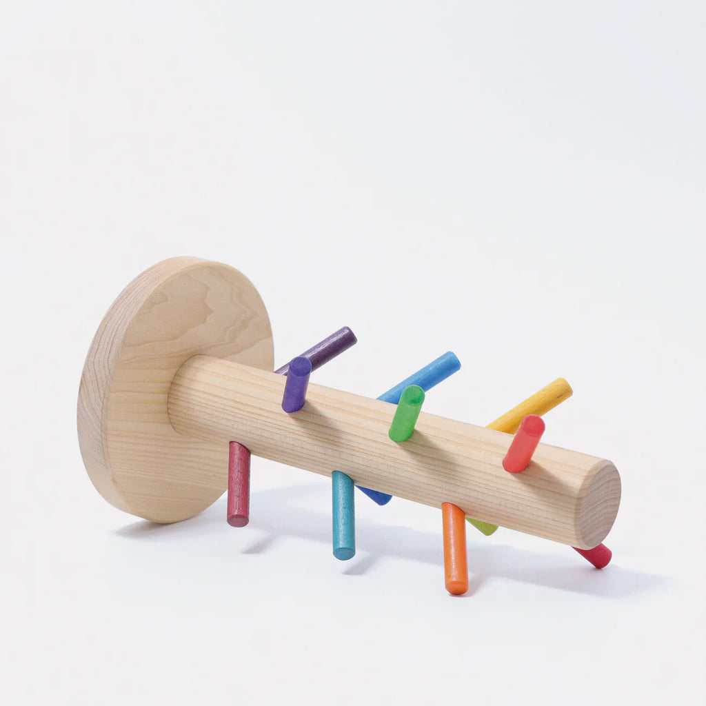 Grimm's Sorting Helper for Building Rings - Rainbow is a wooden toy with a round base, cylindrical handle, and small colorful rainbow dowels sticking out in various directions.