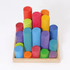 Grimm’s Large Building Rollers Rainbow: a set of multi-colored wooden cylinders of varying heights arranged in a wooden tray for color sorting and motor skills development.