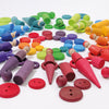 Grimm's Wooden Rainbow Coins (coming soon) are arranged in a vibrant rainbow gradient circle on a white background, sorted by color for a visually appealing and tactile construction display.