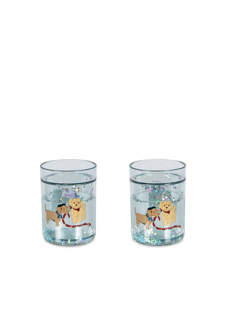 The Konges Sloejd Glitter Cups - Today's Special (2 Pack) feature two clear cups with playful dog illustrations, hats and scarves, plus floating glitter and star confetti—perfect for adding sparkle to kids' drinks.